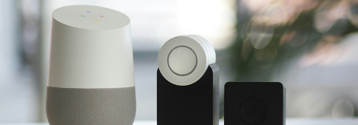 white and gray Google smart speaker and wo black speakers