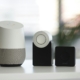 white and gray Google smart speaker and wo black speakers