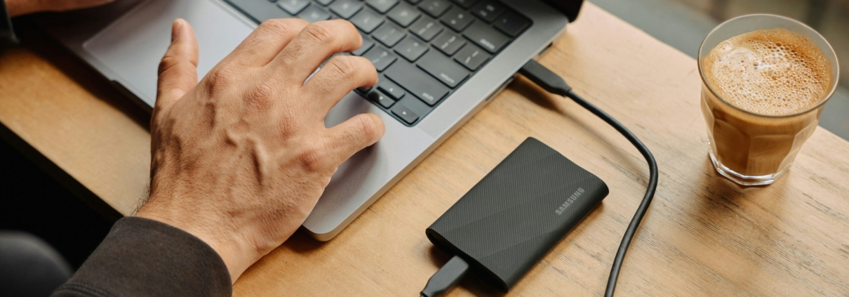 A man sitting at a table using a laptop computer