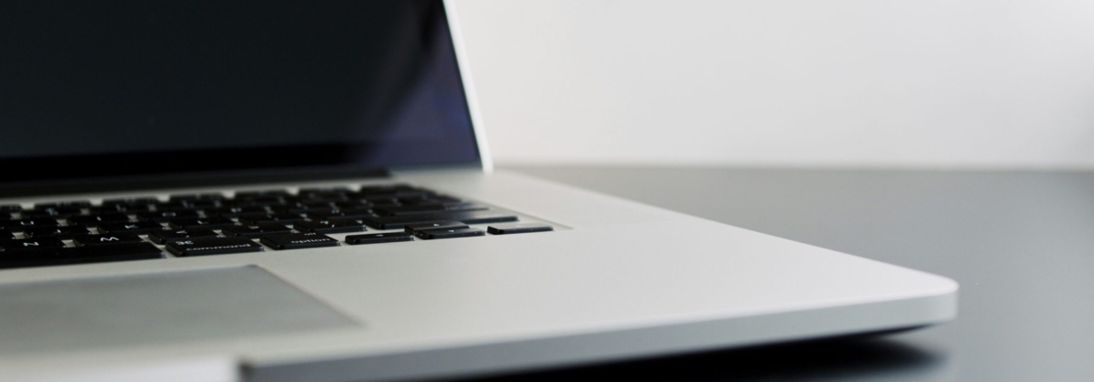 silver laptop computer on black table